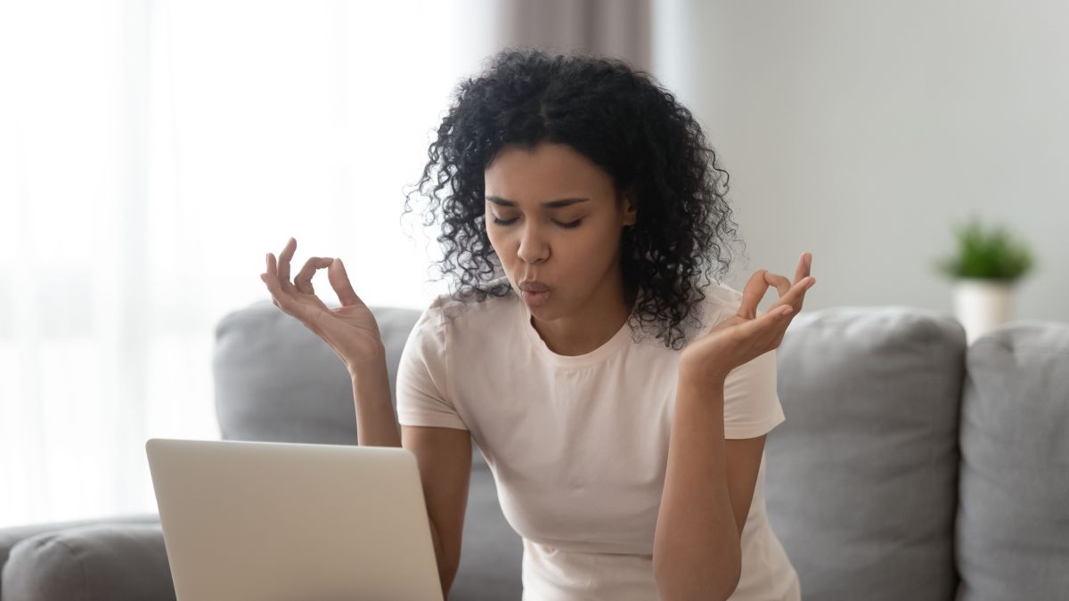 woman sit on couch near laptop take break reduce stress do yoga meditation exercise to calm down self control get rid of negative emotions, bad e-mail, difficult task, problems at work concept